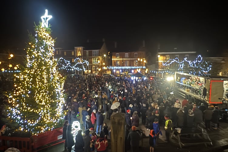 A view over the market square showing the Town Band playing Carols on the back of a lorry.  Courtesy of the Crediton Courier